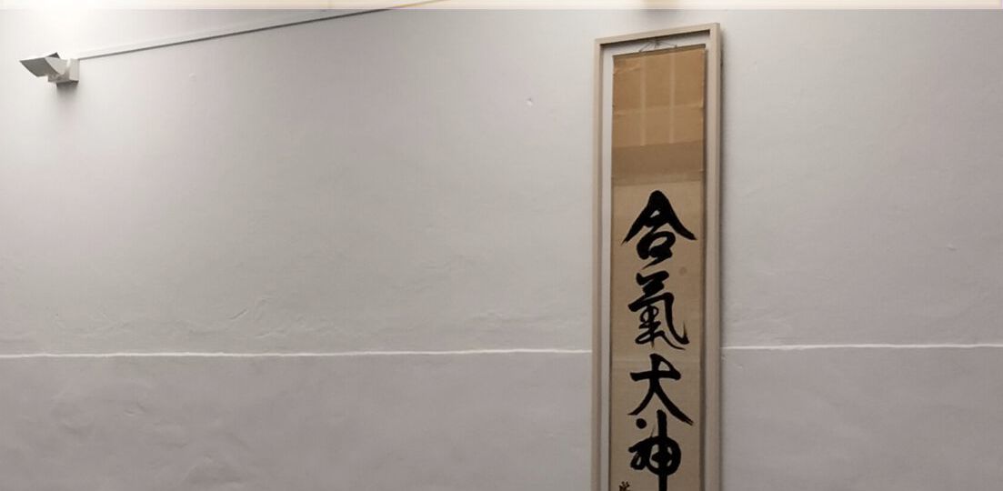 Aikidoraum mit Matten und Schriftzeichen an der Wand
