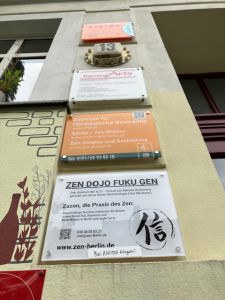 Schild Zen Dojo Fuku Gen Hauswand mit bunten Schildern